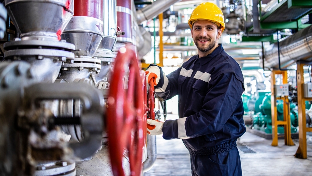 Operatør betjener kjemisk prosessutstyr i industrilokale.
